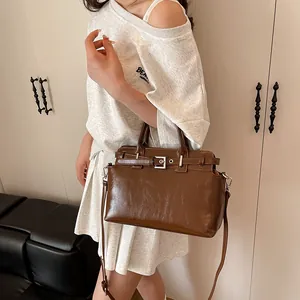 Petit sac carré marron en similicuir brillant avec poignées et bandoulière à boucle