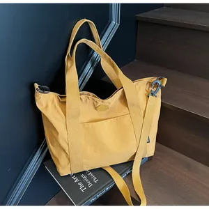 Gros plan d'un sac cabas jaune moutarde avec bandoulière réglable et tissu texturé
