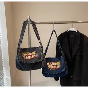 Close-up of vintage denim messenger bags with graphic print and adjustable straps