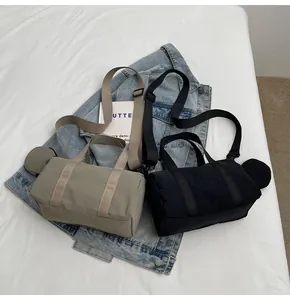 Détail des sacs polochons kaki et noirs avec petits porte-monnaie ronds amovibles