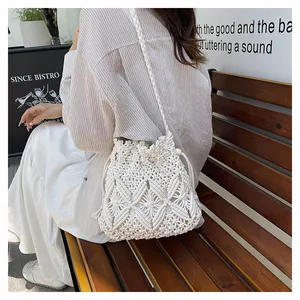 Detail of white hollow woven bucket bag with drawstring closure for beach vacation style