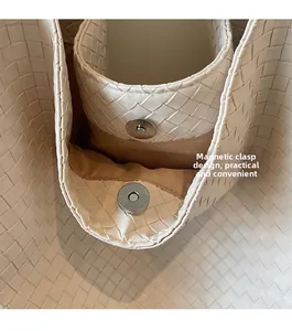 Detail of off-white woven tote bag featuring a practical magnetic buckle closure system