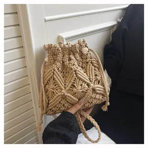 Close-up of handmade crochet hollow bucket bag with wooden beads and tassel drawstring