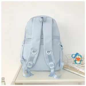 Détail d'un sac à dos scolaire bleu clair avec bretelles en S et poche latérale