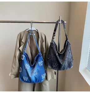 Detail of vintage denim tote bags with frayed letter patches and durable metal hooks