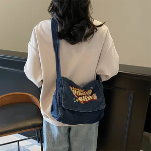 Deep blue denim messenger bag with retro embroidery and adjustable strap