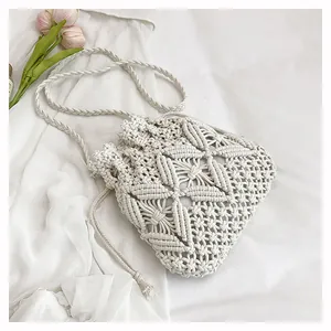 Detailed macro view of beige hollow woven bucket bag with stars and diamond patterns