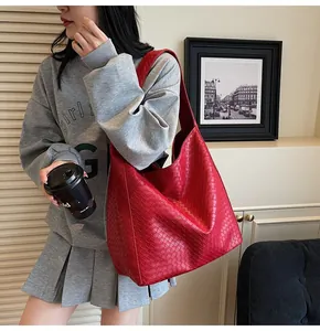 Detail of red woven leather hobo bag showing intricate texture and wide strap