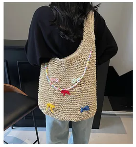 Detail of hand-woven tote bag with colorful beaded straps and knit bow accents