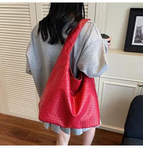 Detail of red woven leather hobo bag showing large capacity and soft texture on model