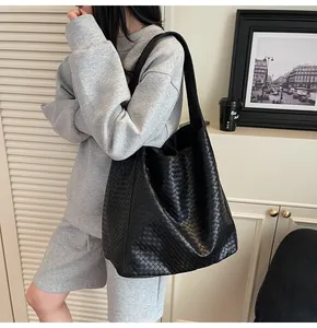 Detail of black woven leather hobo bag showing the texture and slouchy commuter style