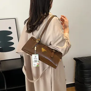 Braune Leder-Baguette-Tasche mit goldenem Dreiecks-Logo und schickem verstellbarem Riemen