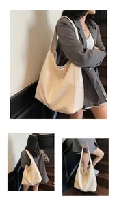 Detail of wide shoulder strap and woven texture on this large cream bucket tote bag