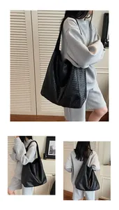 Detail of hand-woven black leather tote bag with wide strap for daily commute