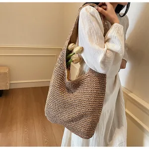 Detailed texture of handcrafted woven hobo bag in brown straw with elegant interior space