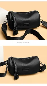 Detail der schwarzen Zylindertasche mit Lychee-Muster, Silberreißverschluss und Gurt