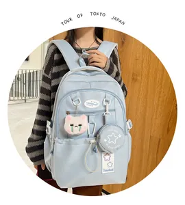 Détail du sac à dos scolaire bleu clair avec mini-sac étoile et porte-clé chat en peluche