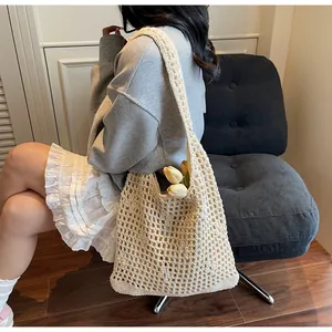 Detail of crochet knit tote bag showing lightweight mesh pattern and casual shoulder wear