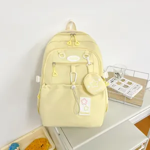 Détail d'un sac à dos scolaire jaune clair imperméable avec patch étoile et mini pochette