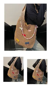 Close-up of handmade woven tote bag with colorful knitted bows and beaded chain detail