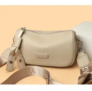 Detail der beigefarbenen Crossbody-Tasche aus strukturiertem Leder mit breitem Gurt