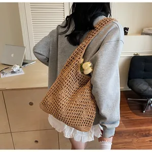 Detail of a brown woven bucket bag showing its hollow pattern and spacious interior
