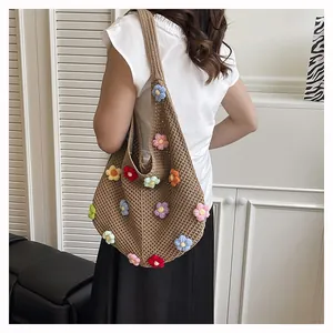 Detail of handmade brown crochet tote bag featuring colorful 3D knitted flower accents