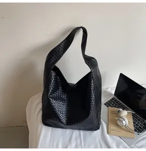 Detail showing high-quality black woven leather texture and Intrecciato craftsmanship