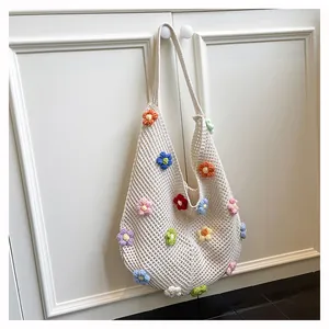 Macro detail of hand-knitted white crochet tote bag with colorful 3D floral embroidery