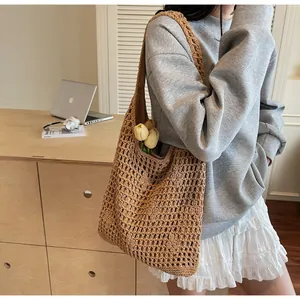 Detail of tan hollow-out woven bucket bag with dark lining shown in a lifestyle setting