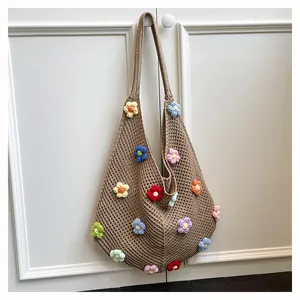 Close-up of handmade crochet tote bag with colorful flower patterns and hollow mesh