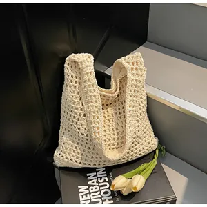 Detail of cream woven crochet bucket bag with hollow mesh texture and cotton lining