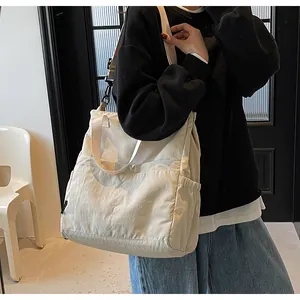 Gedetailleerd overzicht van de crèmewitte grote draagtas met multi-pocket design op het model