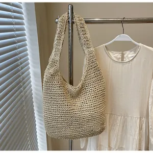 Close-up of a beige handmade woven tote bag with natural straw texture for beach vacation