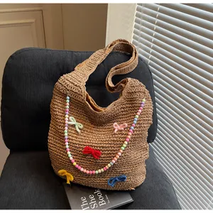 Detail of hand-woven tote bag with colorful beaded handles and knitted bow decorations