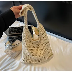 Detailed texture of off-white hollow woven hobo bag for summer beach vacation style