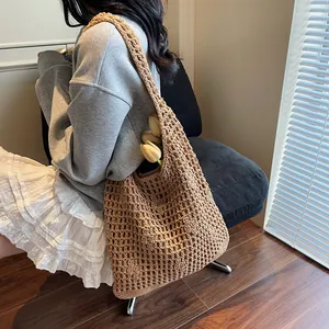 Hollow out woven bucket bag for beach vacation shown on shoulder with floral accents