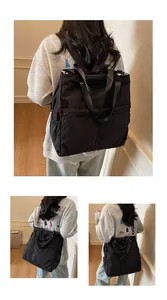 Detail van zwarte multifunctionele rugzak van nylon met ruime vakken en dubbele handvaten