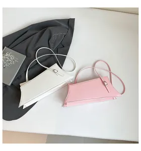 Détail de sacs à bandoulière géométriques en blanc et rose avec boucles métalliques élégantes