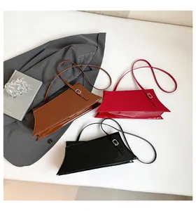 Sacs à bandoulière en cuir verni chic en marron, rouge et noir sur fond blanc minimaliste
