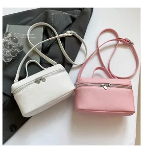Détail de mini sacs carrés en cuir blanc et rose avec fermeture éclair argentée double