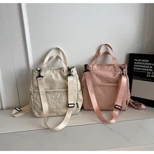 Detail van gebroken witte en roze nylon draagtassen met handvatten en riemen