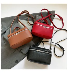 Trois sacs bandoulière minimalistes en marron, rouge et noir avec texture grainée