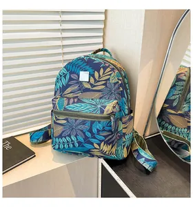 Detail of tropical leaf print canvas backpack featuring front zipper pocket and side pockets
