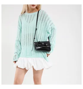 Chic black crossbody bag with bow detail paired with a mint green hollow knit sweater