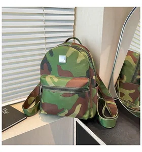 Detailed view of the camouflage backpack with front zipper pocket and metal logo plate