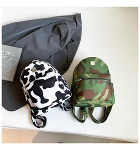 Close-up of mini cow print and camouflage backpacks with stylish front zipper pockets