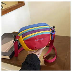 Detail of multi-color patchwork crossbody bag with vibrant embroidery and red strap