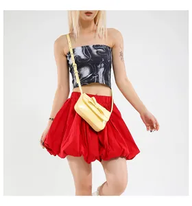 Detail of light yellow crossbody bag featuring a glossy finish and a 3D bow decoration