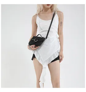 Détail du mini sac selle en cuir grainé noir avec chaîne argentée et boucle métal